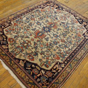 Navy and rust floral patterned rug with a cream field rests on distressed golden hardwood planks.