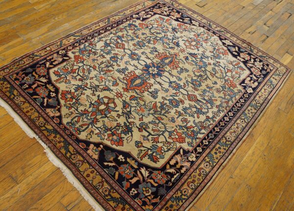 Navy and rust floral patterned rug with a cream field rests on distressed golden hardwood planks.