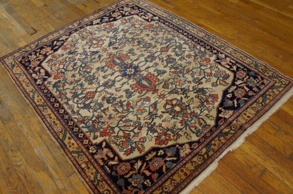 Traditional cream rug with rust, light blue, and navy floral designs on distressed hardwood floors.