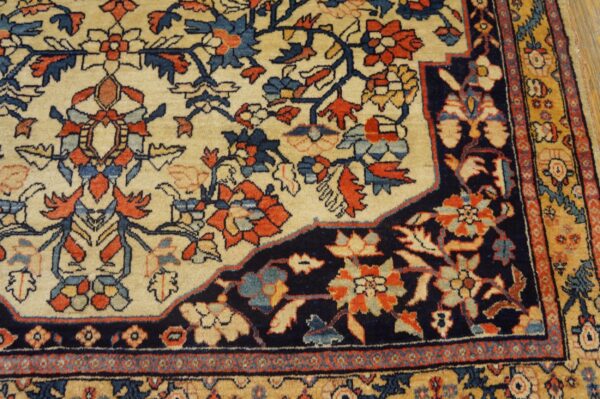 Ornate traditional rug showing a cream field, dark navy corner, and detailed red, blue, and gold floral designs.