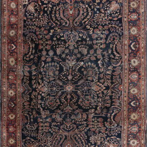 Deep navy rug with intricate floral and animal motifs and a wide rust red border.