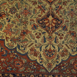 Intricate floral and vine patterns cover this low-pile rug with rust, khaki, and navy blue colors.