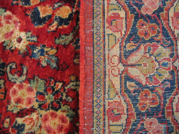 Detailed view showing two contrasting rug patterns, a high-pile red floral and a low-pile navy geometric border.