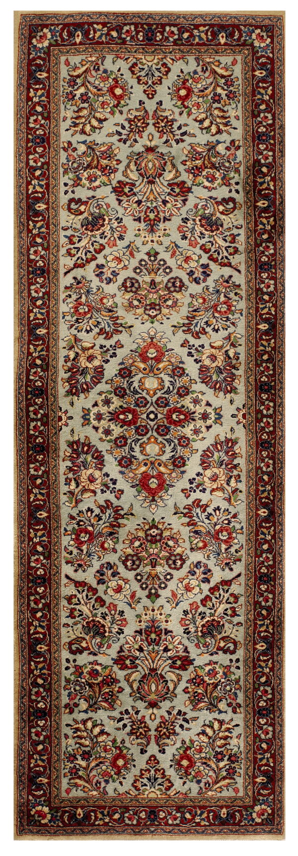 A low pile runner rug displaying a dense floral pattern in red, gold, and blue on a pale blue field.