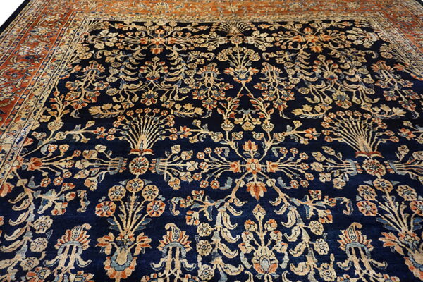 Dark blue traditional rug with a detailed repeating floral pattern in cream, rust, and orange.