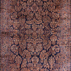 Navy blue area rug featuring a dense, traditional floral pattern in muted rust and terracotta tones.