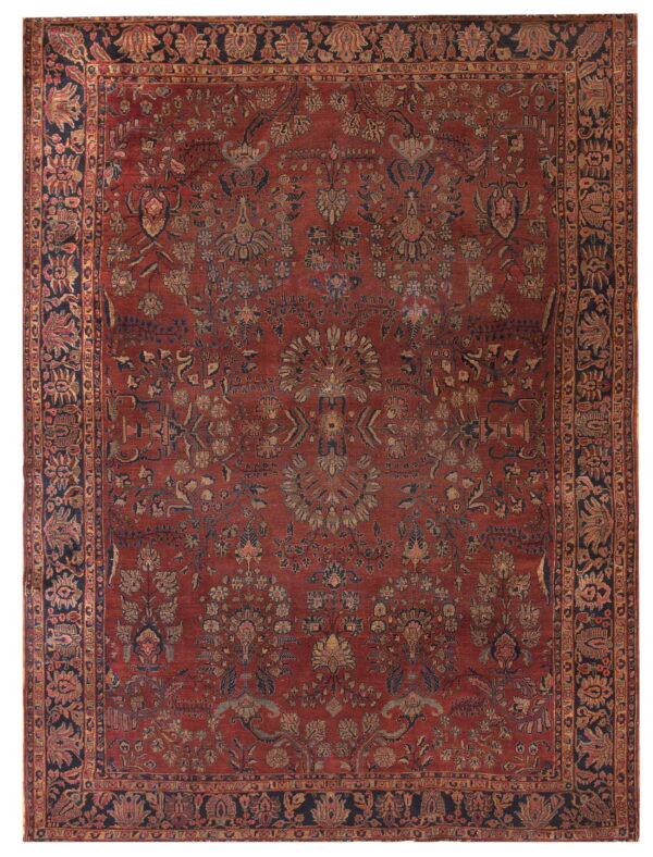 Ornate, low-pile rug featuring a dense floral pattern in a distressed red, navy, and gold color palette.