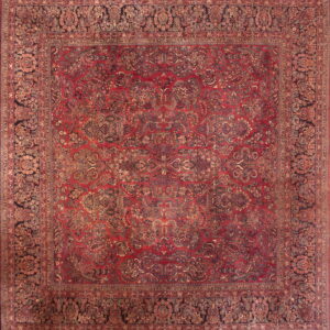 Detailed view of a square rug with a dense red and black traditional floral pattern and ornate borders.
