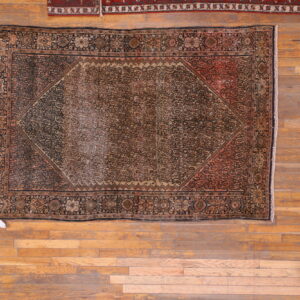 Worn antique rug with intricate patterns.
