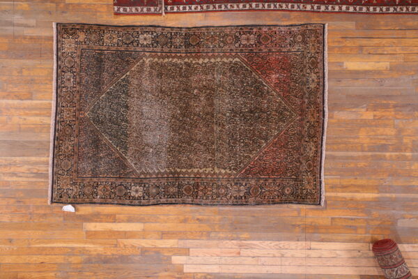 Worn antique rug with intricate patterns.