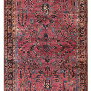 Muted red rug with complex floral designs and a medallion pattern in blue, navy, and tan.