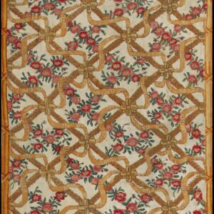 Cream rug patterned with red roses and a repeating lattice of gold and brown woven ribbons.