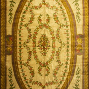 Ornate cream rug featuring an oval brown border frame and garlands of rose and green flowers.