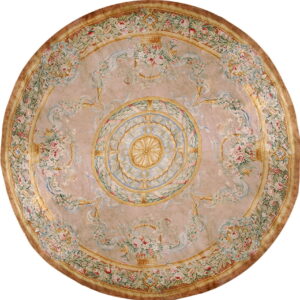 Round rug with a blush background featuring a detailed central medallion and floral garlands in pink, green, and blue.