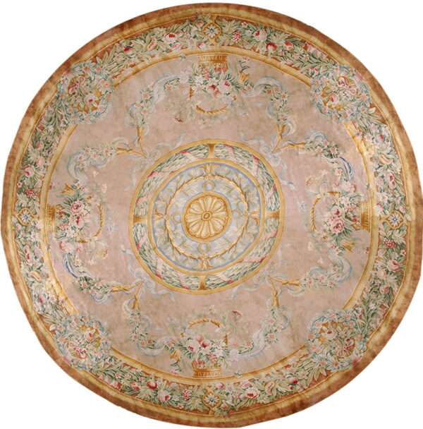 Round rug with a blush background featuring a detailed central medallion and floral garlands in pink, green, and blue.