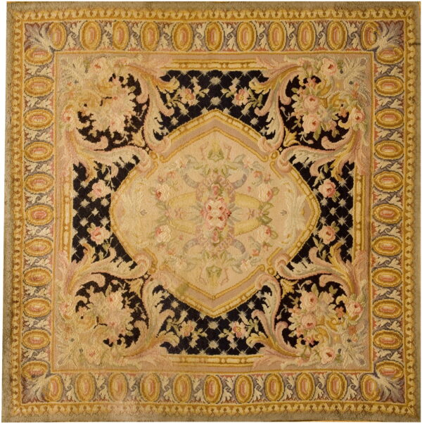 Ornate black, beige, and pink rug with a central medallion and elaborate floral borders.