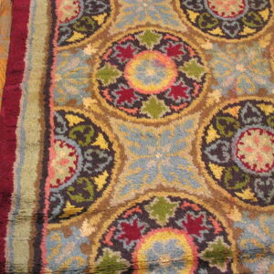 High pile rug featuring multicolored circular medallions and floral motifs rests on hardwood planks.