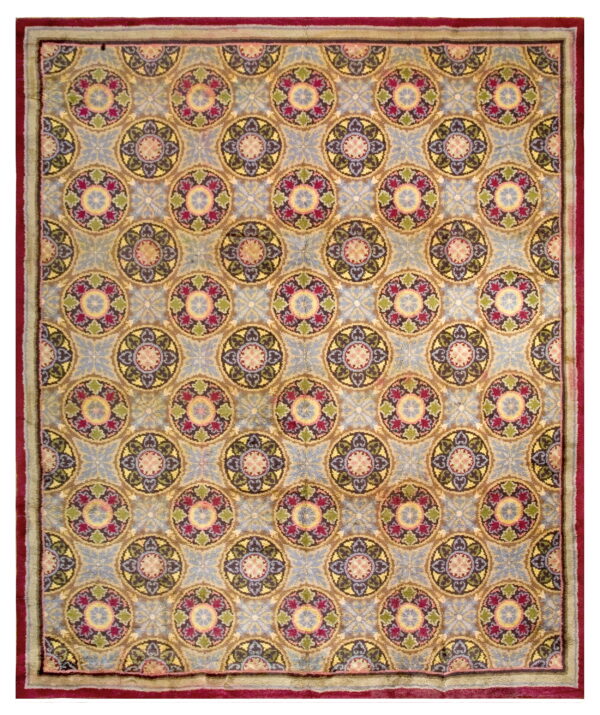 Square rug with blue background, multi-color medallions, and a wide crimson and sage green border.