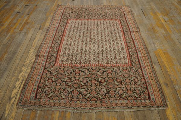 Low-profile rug featuring intricate red, black, and pale designs rests on distressed wooden planks.