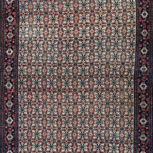 Low-pile rug with a cream field, dense red and blue geometric pattern, and intricate dark blue borders.