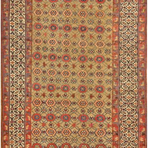 Low-pile runner rug with a tan ground, red geometric floral medallions, and elaborate cream borders.
