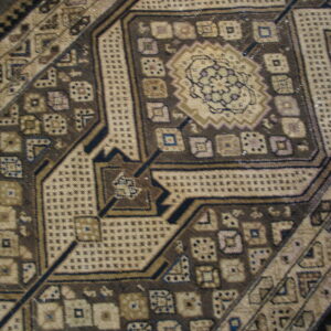 Detailed view of a brown and beige geometric rug pattern with blue and purple accents.