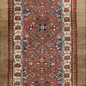 Runner rug featuring a dense red and blue traditional geometric pattern with wide floral cream borders.