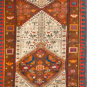 A reddish-brown and cream geometric pattern runner rug rests on distressed wood plank flooring.