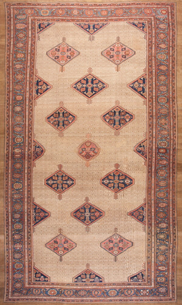 Elongated beige rug featuring repeating geometric diamond motifs in navy, rust, and muted pink borders.