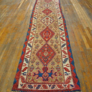 Red, blue, and beige geometric runner on a distressed wood plank floor.