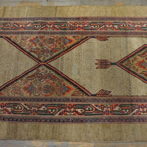 Beige geometric runner with elaborate red, blue, and dark-toned diamond motifs on wood floor.