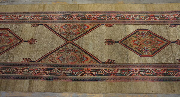 Beige geometric runner with elaborate red, blue, and dark-toned diamond motifs on wood floor.