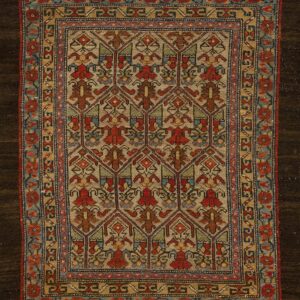 Low-pile area rug displaying intricate geometric and stylized botanical motifs in red, blue, and brown on a tan ground.