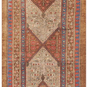 A narrow rug runner with rust, cream, red, and blue geometric medallions and patterned borders.