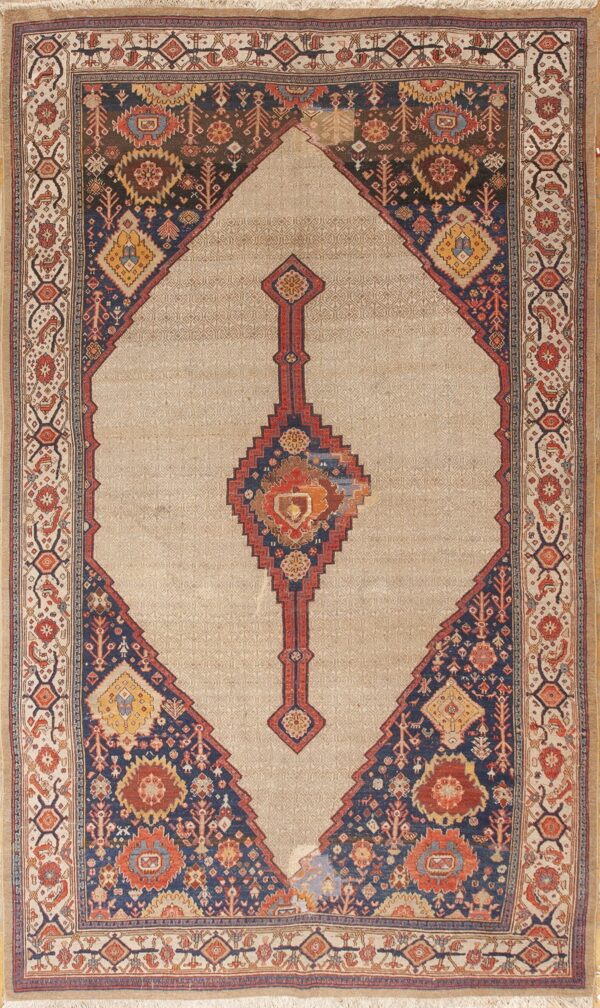 Beige rug with a large stepped diamond containing dark blue, red, and gold tribal designs.