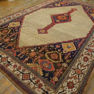 Traditional rug with a beige geometric field, red medallion, and dark navy, rust, and brown multicolored borders on wood planks.