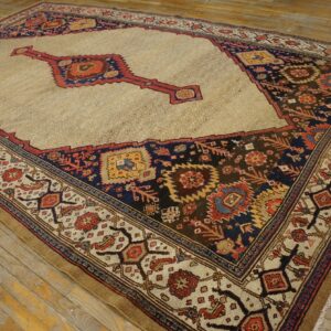 Beige field rug with a subtle geometric pattern, dark borders, and rust and navy medallions on wood floors.