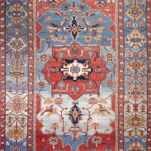 Ornate traditional rug with a central medallion pattern in striking red, deep blue, and light blue.
