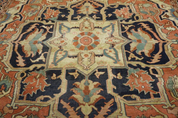 Low-pile rug with a complex star medallion pattern in navy, rust, and pale green colors.