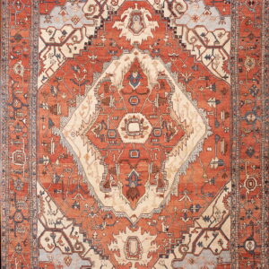 Geometric patterned rug in shades of rusty orange, ivory, and slate blue with multiple ornate borders.