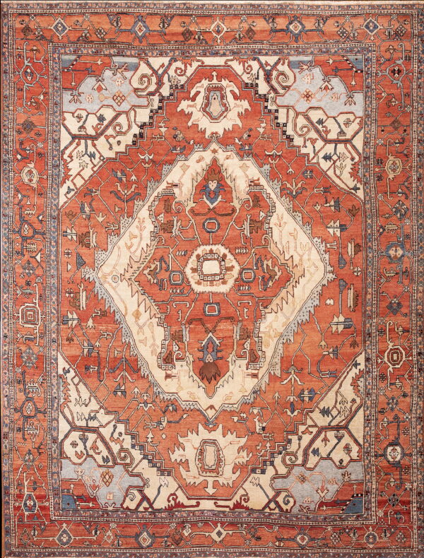 Geometric patterned rug in shades of rusty orange, ivory, and slate blue with multiple ornate borders.