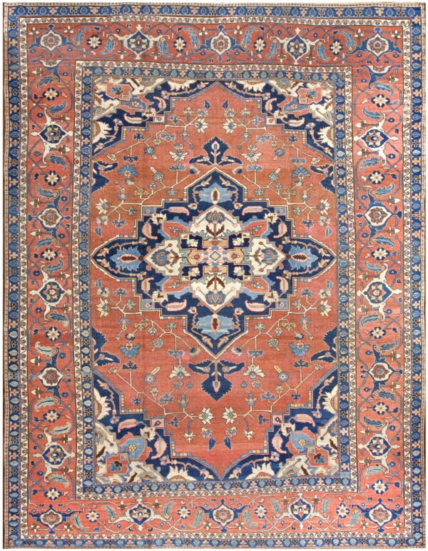 Ornate traditional rug featuring a large navy and cream geometric medallion on a reddish-orange field.