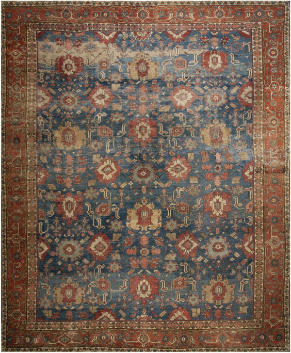 Distressed traditional rug with an indigo field, rust border, and all-over pattern in red, tan, and light gray.
