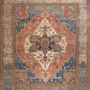 Large traditional rug featuring a central medallion and ornate borders in rust, navy, cream, and muted blue.