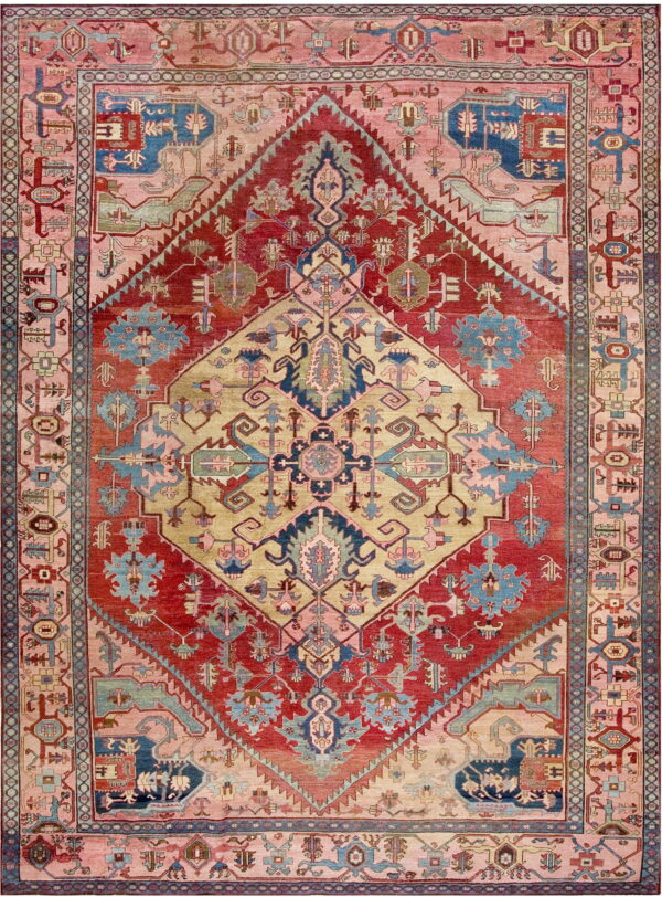 Low-pile rug with geometric patterns in red, gold, blush pink, and blue, centered by a large diamond motif.