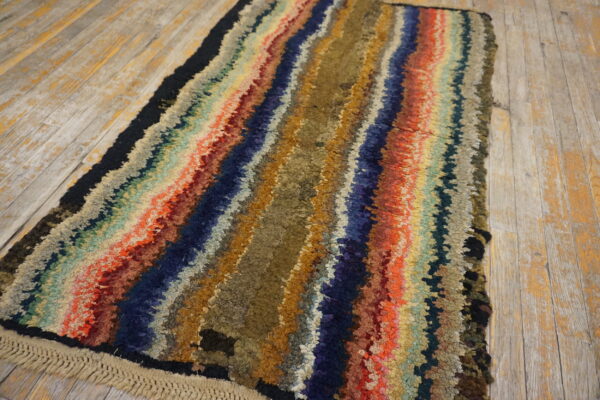 High-pile shaggy runner rug with multicolored, wavy stripes lies on distressed wood planks.