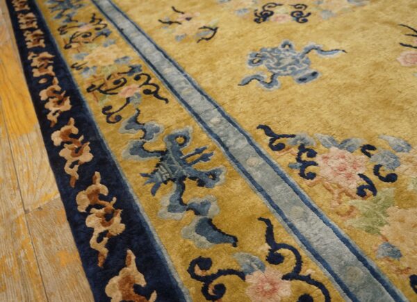 Golden yellow high-pile rug detail showing blue, pink, and brown traditional patterns and wood flooring.