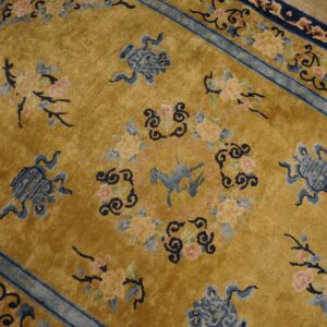 Gold rug with a stylized blue horse, floral bouquets, and complex blue borders on wooden flooring.