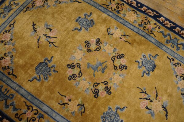 Gold rug with a stylized blue horse, floral bouquets, and complex blue borders on wooden flooring.