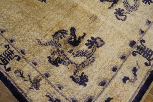 Textured beige rug featuring dark blue stylized dragon patterns and faded purple border details.